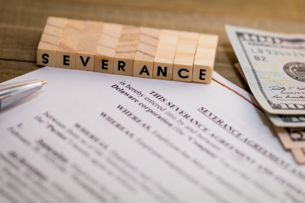 Severance agreement document with cash and pen, symbolizing employment law and severance review services by Hershey Law