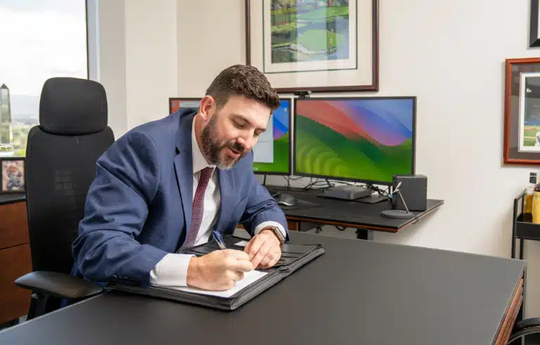 Male Lawyer on a desk writing - Hershey Law